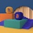Two platform structures with stairs are positioned side by side. One platform is orange with an orange and purple 'Tezos' symbol on top, while the other is green with a blue and orange 'Bitcoin' symbol. The platforms are set on a blue and mustard yellow background, and there is a large circular arch in the backdrop.